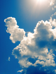 vertical view of clouds and sunshine over blue sky