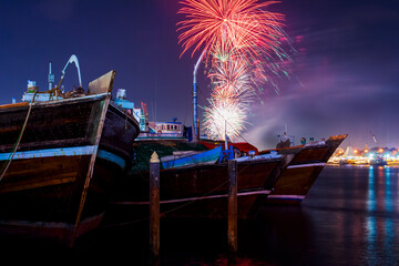 Wall Mural - Fireworks above the boats in Dubai, UAE