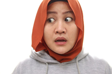 Wall Mural - Asian muslim woman wearing hijab stuned shocked expression looking to the side with big eyes and open mouth