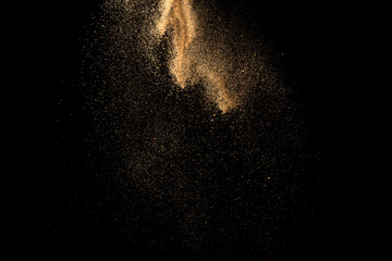 Wall Mural - Gold sand explosion isolated on black background. Abstract sand cloud.