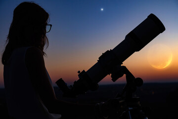 Wall Mural - silhouette of a woman and telescope with twilight sky.