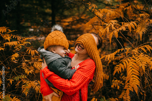 Photographie Handsome caucasian mother in warm grey jacket, black trousers and grey trainers