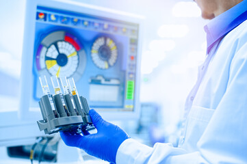 Laboratory assistant in rubber gloves working with a modern immunochemistry analyzer