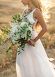 © Damien - Close-up details of a wedding bouquet with wild flowers and white peonies in softlight focus.