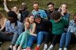 © Roman - portrait of friendly happy youth on grass in the park, multiethnic group of people happy together, share funny stories and hug