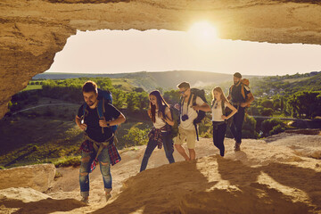 Wall Mural - hiking. friends tourists with backpacks walk along the route in a cave in the mountains in nature.