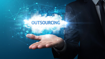 Hand of Businessman holding OUTSOURCING inscription, successful business concept