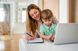 © NDABCREATIVITY - Mother working at home-office with child on her lap