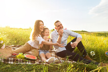 Cute Family Playing Together On A Picnic In Meadow
