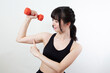 © sho987i - ダンベルを持って二の腕に力を入れる女性