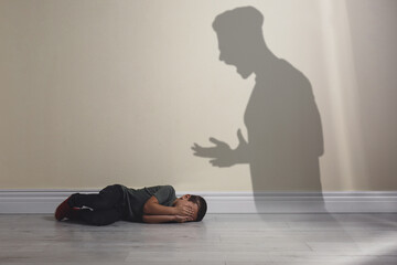 Child abuse. Father yelling at his son. Shadow of man on wall