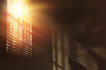 Sun shining through window blinds in room