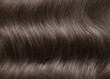 A closeup view of a bunch of shiny straight brown hair in a wavy curved style