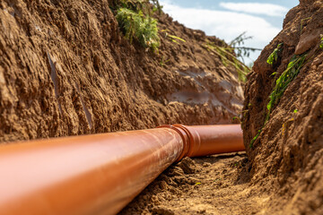 Plastic pipes in the ground during the construction of a building, bunner with copy space