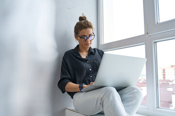 Wall Mural - Calm businesswoman working online on laptop indoors