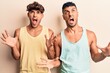 © Krakenimages.com - Young gay couple wearing casual clothes crazy and mad shouting and yelling with aggressive expression and arms raised. frustration concept.