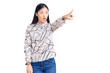 © Krakenimages.com - Young beautiful chinese woman wearing casual shirt pointing with finger surprised ahead, open mouth amazed expression, something on the front