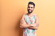 © Krakenimages.com - Young handsome man with beard wearing summer sleeveless t-shirt happy face smiling with crossed arms looking at the camera. positive person.