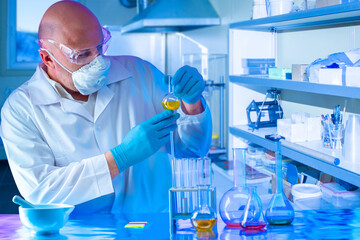 The chemist conducts research in the laboratory. A man in a protective suit and mask with a test tube in his hands. Synthesis of new substances. Analysis of samples of the chemical industry.