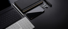 Digital Devices With Smartphone, Tablet, Keyboard, Stationery, Accessories And Copy Space On Dark Table