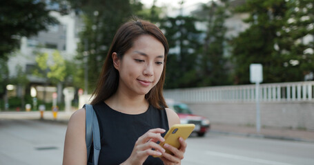 Canvas Print - Woman use of smart phone and walk in the street