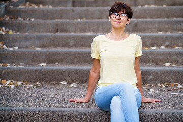 Beautiful Middle-aged woman sit on the street