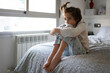 © javiindy - Nine-year-old girl sitting in bed bored by confinement