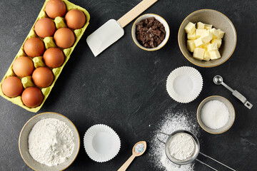 cooking food and culinary concept - butter, eggs, flour, sugar and chocolate on table