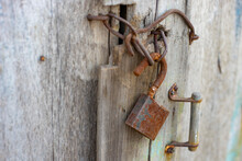 Old Wooden Door With Rusty Handle, Hook And Lock