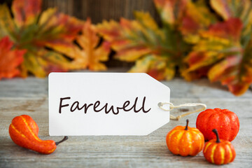Wall Mural - white label with english text farewell. wooden background with autumn decoration like pumpkin and le