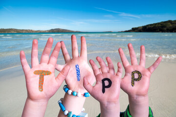 Wall Mural - Children Hands Building Colorful German Word Tipp Means Tip. Ocean And Beach As Background