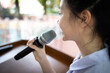 © Satjawat - Asian child girl speaking with microphone voice speaker in seminar room,talk conference in educational,student president is explaining the lecture at the meeting about education,discipline of school
