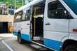 © Ilya_R - Tourist minibus is waiting with the door open in the parking lot. White minibus is parked in sunny weather.