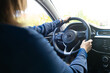© makedonski2015 - A girl in business style is sitting behind the wheel of a car and is going to go to work. Close-up of hands on the steering wheel of a car
