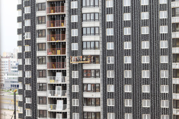 Construction of a multi-storey building. Tall concrete house, glazed windows. Construction works.