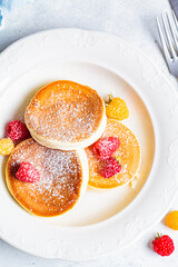 Poster - Japanese fluffy pancakes with raspberries in white plate, white background, top view. Japanese cuisine concept.