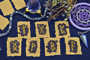 Still life with runes, dreamcatcher and crystals on witch table.