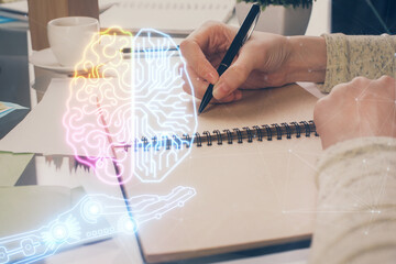 Double exposure of writing hand on background with brain hologram. Concept of learning.