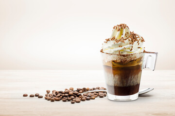 Wall Mural - Cup of coffee with whipped cream, milk foam and chocolate chips on wooden table.