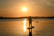 © Akerri - Silhouette of a boy on a paddle board at sunset