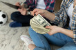 © Studio Peace - Young couple counting money while sitting on floor in new apartment