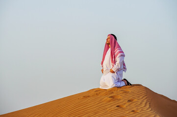 Wall Mural - Portrait of Arabic man on a middle of yellow desert.