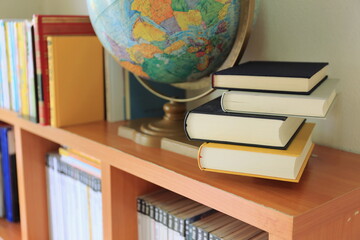 close-up of several books stacked on the bookshelf in the library selective focus and shallow depth 