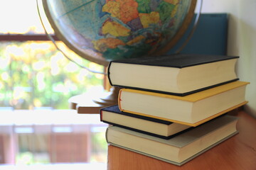 close-up of several books stacked on the bookshelf in the library selective focus and shallow depth 
