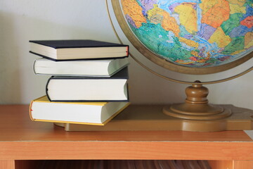 close-up of several books stacked on the bookshelf in the library selective focus and shallow depth 