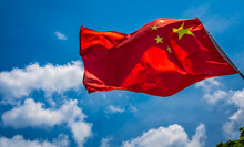 Red Chinese National Flag With Blue Sky Background