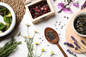 Flat lay composition with healing herbs on white wooden table