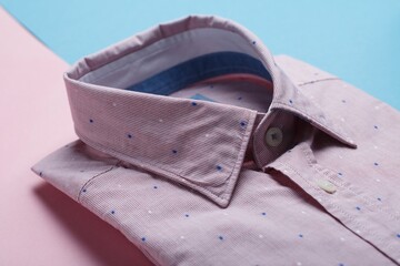 Wall Mural - Pink with blue dots shirt on a pink and blue surface