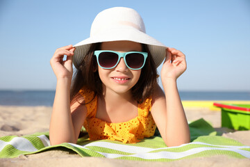 Sticker - Cute little child lying at sandy beach on sunny day