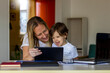 © Jelena Stanojkovic - Happy mom and cute little son having fun,learning using mobile.Mother watching son playing games on tablet.Son and his mother using online media laptop,smartphone and digital tablet.Mobile addiction.